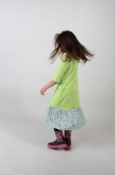 Детское платье с воланом салатового цвета и принтом макаруны фото